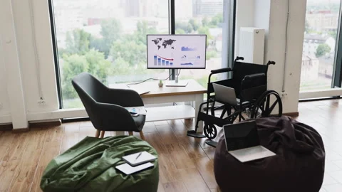 Modern workspace with wheelchairs, computers, and city view for accessibility Stock Footage 317994445