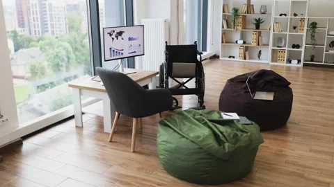Modern workspace with wheelchairs, computers, and city view for accessibility Stock Footage 317994693