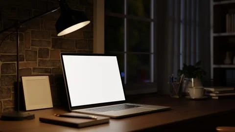Modern workspace with white screen laptop on table beside lamp and brick wa.. 스톡 일러스트