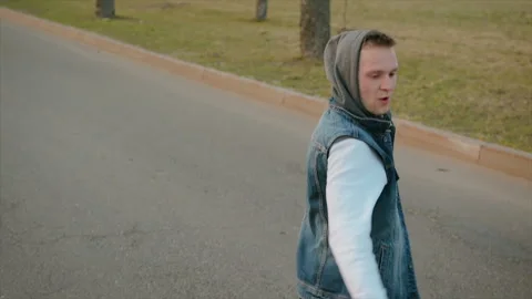 Modern young Caucasian guy dancing the bottom break on the asphalt road with Stock Footage 106603259