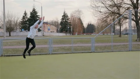 Modern young Caucasian guy performs acrobatic tricks, complex elements on the Stock Footage 106276788