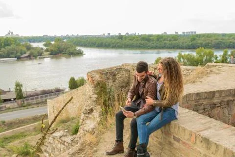 Modern young couple using their mobile phone near the river Foto stock