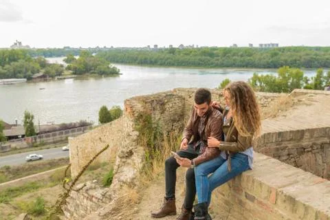 Modern young couple using their mobile phone near the river Foto stock