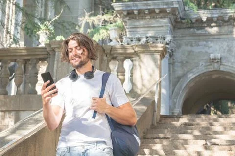 Modern young man talking on smart phone outdoors Stock Photos