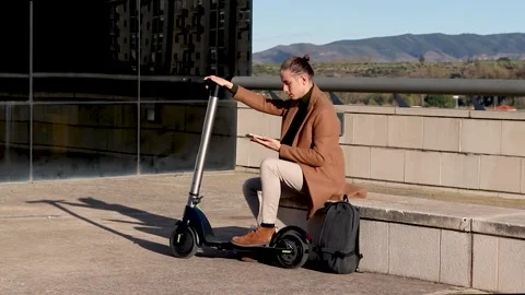 Modern young man texting on the smartphone with electric scooter Stock Footage 187040986