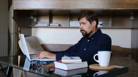 Modern young man working remotely from home Stock Footage 143868373