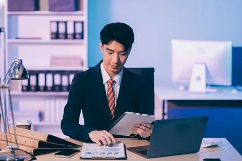 Modern young man working remotely from home at night. 스톡 사진