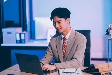 Modern young man working remotely from home at night. 스톡 사진