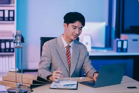 Modern young man working remotely from home at night. 写真素材