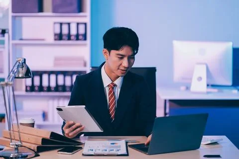 Modern young man working remotely from home at night. 스톡 사진