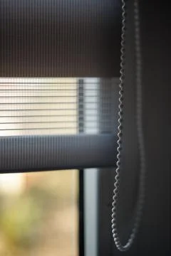 Modern zebra-pattern roller blinds with a ball-shaped cord for raising or l.. Stockfoto's