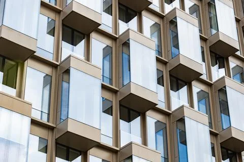 Modernist building creating a geometric pattern with glass windows and balconies Stock Photos