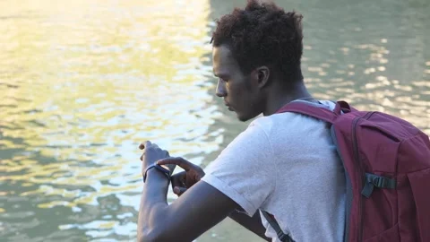 Modernity, device - concentrated young african man typing on his smartwatch Stock Footage 240338618