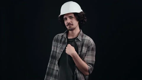 The modest hipster engineer, with a white helmet, smiles a little, points to him Stock Footage 156279377