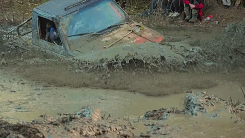 A modified 4x4 SUV navigates a mud swamp during an extreme off-road competition Stock Footage 345497268