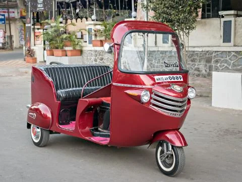 Modified and decorated red colored three wheeler autorikshaw on the street. Stock Photos
