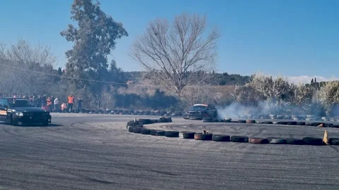 Modified Drift Car Performing Donuts and Sharp Turns on Race Track with Smoke Stock Footage 327402924