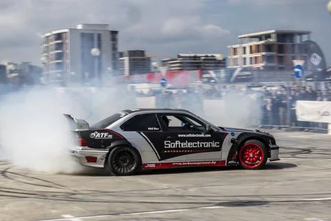 A modified drift car slides sideways in a cloud of tire smoke Stock-Fotos