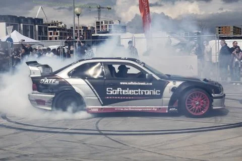 A modified drift car slides sideways in a cloud of tire smoke Stock-Fotos
