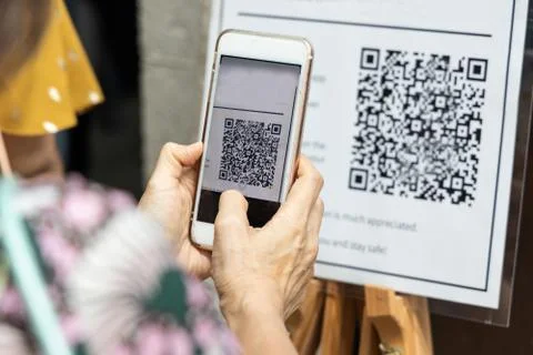Modified inactive QR Code used.  Person scanning QR code with smartphone to r Stock Photos