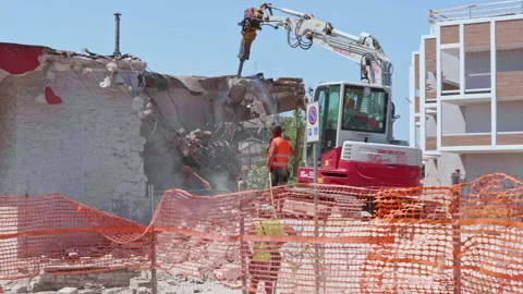 Modugno, Italy - August 7, 2024: an excavator demolishes a small building mad Video stock 281642212