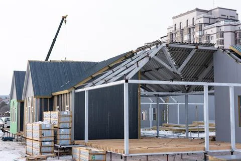 A modular building under construction with metal frames and a crane operati.. Stock Photos
