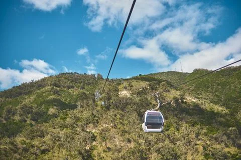 Modular cabins cable car against the bright sky, clouds ans mountains. Cableway Stock Photos