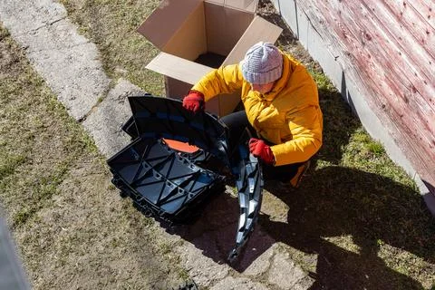 Modular compost system with stackable plastic parts being unpacked by rural.. Stock Photos