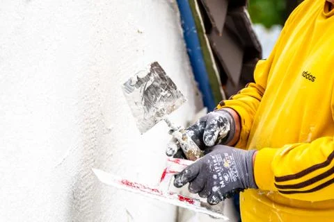 Moers / Germany - March 26 2019 : Construction worker plastering and smoothing Stock Photos