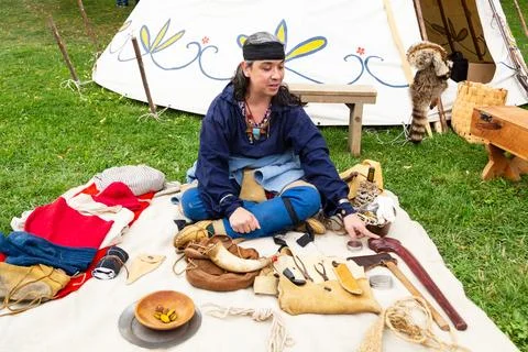 Mohawk native man sitting next to his weapons Stock Photos