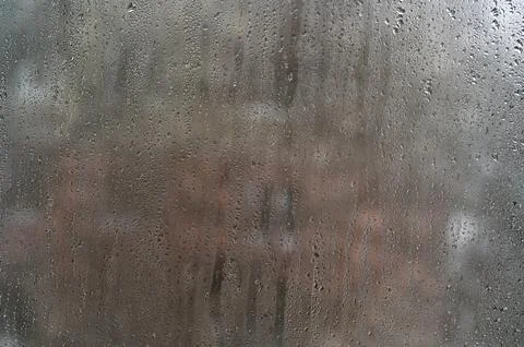 Moisture beads run down fogged glass. Stock Photos
