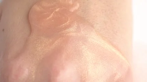 Moisturizing lotion with shimmer pouring into open hand. Skin care concept Stock Footage 254961834
