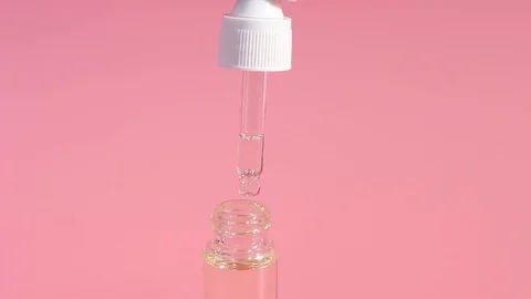Moisturizing serum dropper with a close up on a pink background, front view Stock Footage 123899446