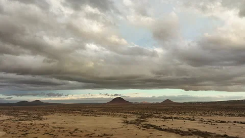 Mojave Desert an distant buttes with the tiny silhouette of a lone human 스톡 동영상 231199411