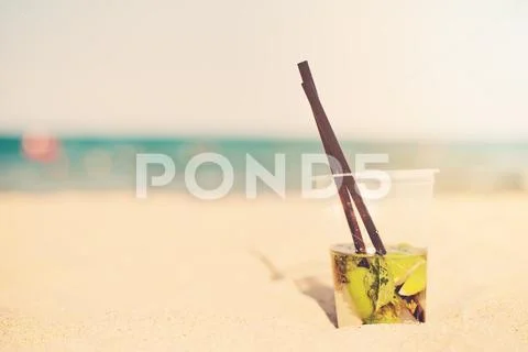 Mojito cocktail on the beach, blurred beach background. Sun, sun haze, glare Stock Photos