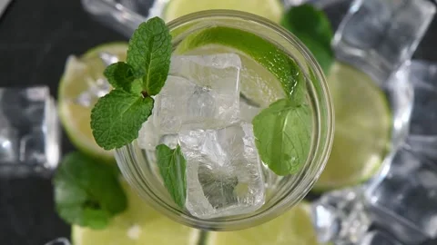 Mojito magic. Top down rotating cocktail glass on dark background. Cinematic mac Stock Footage 324894229