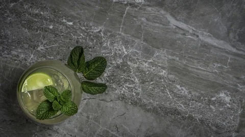 Mojito summer cocktail with mint garnish on a marble stone background Vídeo Stock 106027346