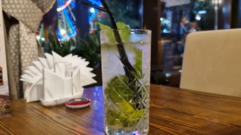 Mojito, tonic with mint, lemon and ice cubes close-up Stock Footage 245719899
