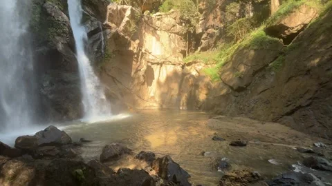 Mok Fa Waterfall flowing into clear natural pool with rocky cliff 스톡 동영상 331023731