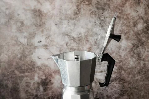 Moka pot coffee maker on grunge texture wall. Stock Photos