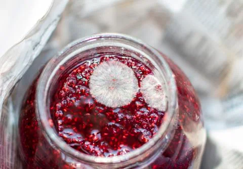 Mold in a jar of raspberry jam. Hazardous to health. Stock Photos
