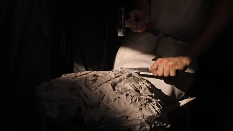 Mold maker use hammer with chisel to crack plaster mold before take off piece of Stock-Footage 130111012