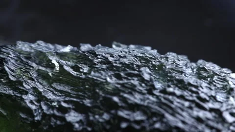 Moldavite gemstone extreme close up. Precious tektite from the Czech Republic Stock Footage 294316844