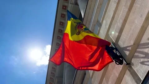 Moldovan flag on facade flagpole against bright sunlight, low angle. Stock Footage 219000909