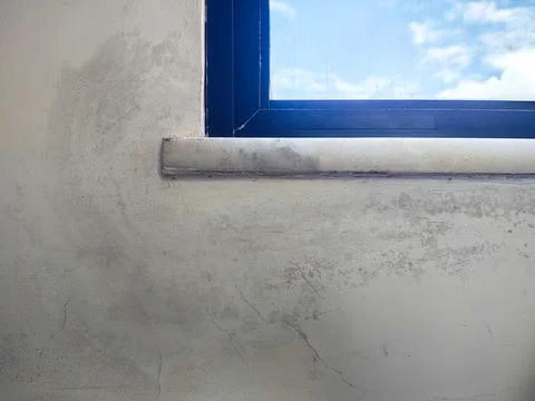 Moldy wall beneath a closed window Stock Photos