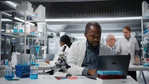 Molecular biologist in lab analyzing batch of blood samples 스톡 사진
