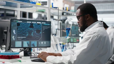Molecular biologist uses computer displaying DNA data, removing eyeglasses Stock Footage 320146556
