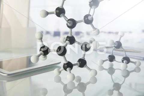 Molecular Model And Digital Tablet On Counter In Lab