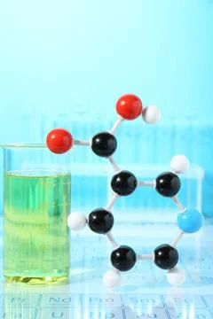 Molecular model and laboratory glassware against light blue background Stockfoto's