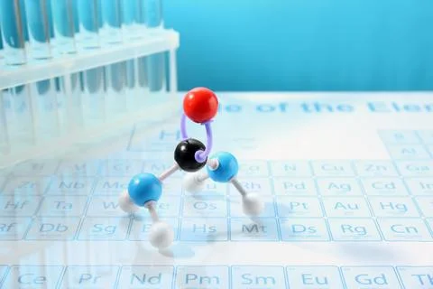 Molecular model and test tubes on periodic table against light blue backgro.. Stockfoto's